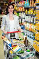 Smiling woman pushing trolley in aisle