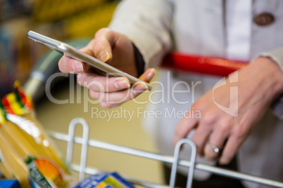 Woman using her smartphone in aisle