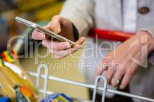 Woman using her smartphone in aisle