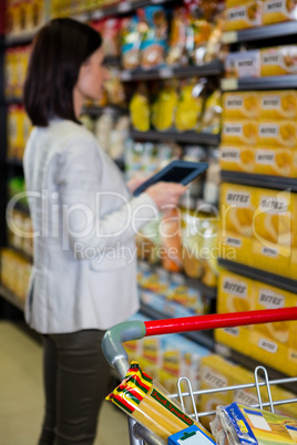 Woman using her tablet pc in aisle