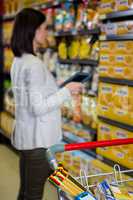 Woman using her tablet pc in aisle