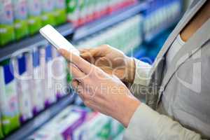 Woman using her smartphone in aisle