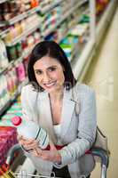 Smiling woman holding milk bottle