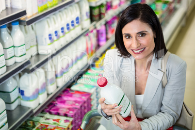 Smiling woman holding milk bottle