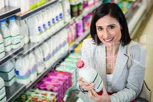 Smiling woman holding milk bottle