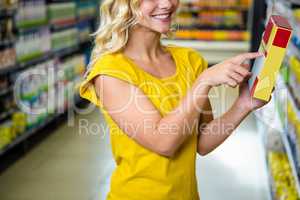 Smiling pretty blonde woman pointing a box