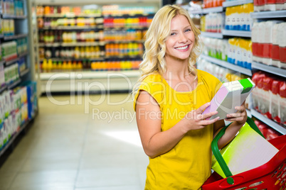 Smiling woman with basket holding a box