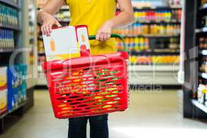 Woman putting box in shopping basket