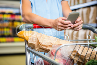 Woman using her smartphone in aisle