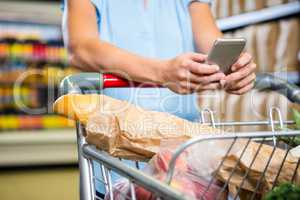 Woman using her smartphone in aisle