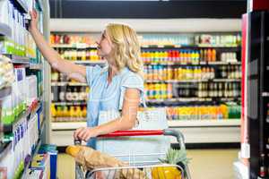 Smiling woman picking dairy products