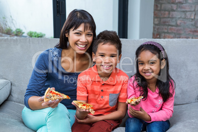 Happy  family eating pizza on the sofa