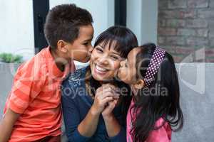 Happy mother being kissed by her children