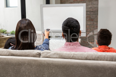 Happy family watching tv on the sofa