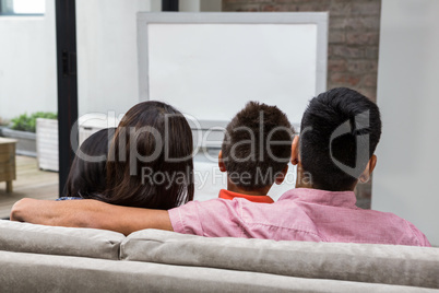 Happy family watching tv on the sofa