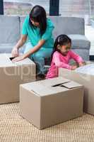 Happy mother and daughter opening boxes