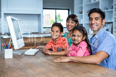 Happy family using computer in the kitchen