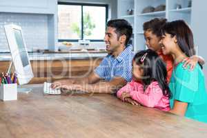 Happy family using computer in the kitchen