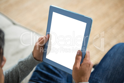 Handsome man using tablet on the sofa in living room