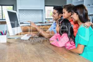 Happy family using computer in the kitchen