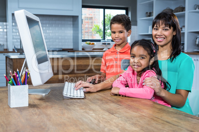 Happy mother using computer with her children