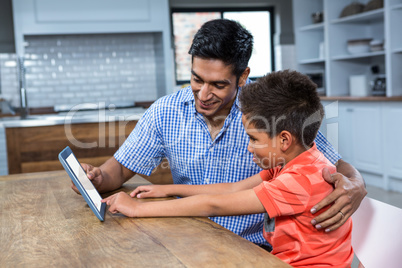 Smiling father using tablet with his son