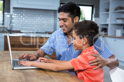 Smiling father using laptop with his son Smiling father using laptop with his son