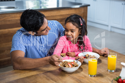 Happy father having breakfast with his daughter