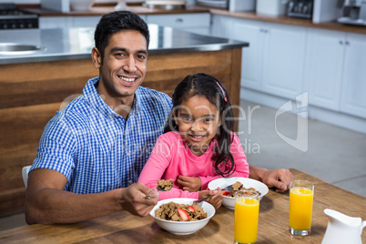 Happy father having breakfast with his daughter
