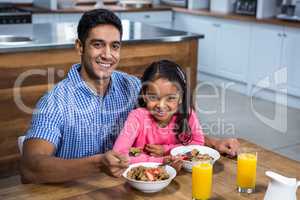 Happy father having breakfast with his daughter