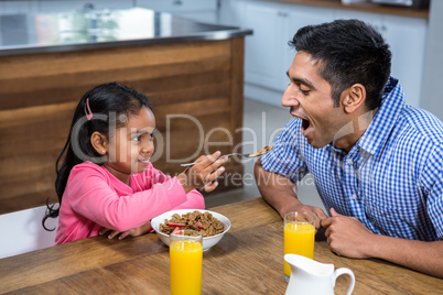 Cute daughter feeding his father