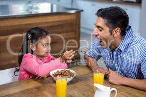 Cute daughter feeding his father