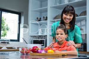 Smiling woman cooking with her son