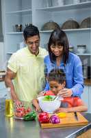 Happy family preparing salad in the kitchen