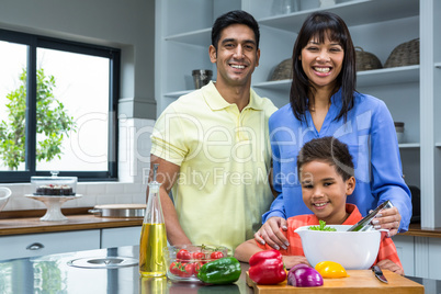 Happy family preparing salad in the kitchen