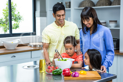 Happy family preparing salad in the kitchen