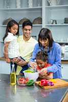 Happy family preparing salad in the kitchen