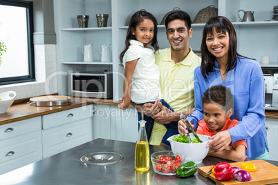 Happy family preparing salad in the kitchen