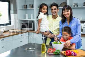 Happy family preparing salad in the kitchen