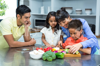 Happy family slicing vegetables