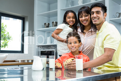 Happy family in the kitchen ready to eat biscuits