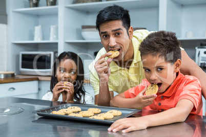 Smiling father with his children eating biscuits