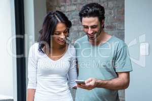 Smiling couple using smartphone together