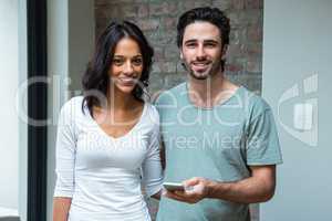 Happy couple using smartphone in living room