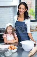 Smiling mother and daughter ready to cook