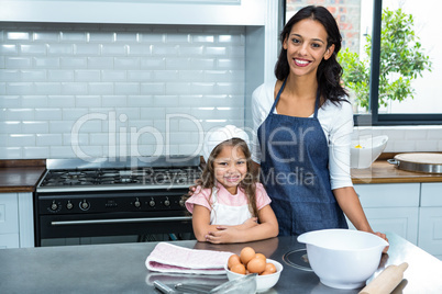 Smiling mother and daughter ready to cook