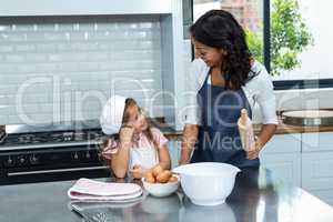 Smiling mother and daughter ready to cook in the kitchen