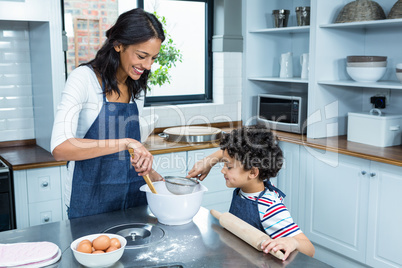 Smiling mother cooking with her son