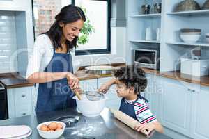 Smiling mother cooking with her son