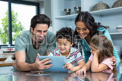 Happy family using tablet in kitchen